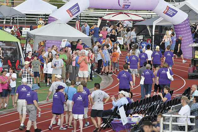 People participate in the Survivor's Lap at the American Cancer Society's Relay for Life in White Bear Lake