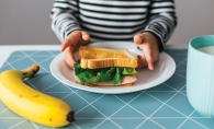 A child eats a meal provided by the White Bear Area Food Shelf