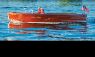 Pat and Susan Oven sit in their Chris-Craft on White Bear Lake watching A scow races.