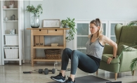 A woman performs online exercises from the YMCA at home.