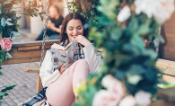 A woman sits reading a book on her newly-remodeled porch