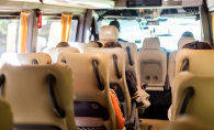 Several people sit inside of a shuttle bus.