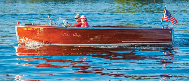 Pat and Susan Oven sit in their Chris-Craft on White Bear Lake watching A scow races.