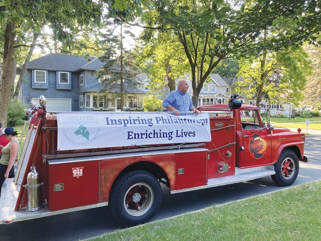 Bill Foussard on a old fashioned fire truck.