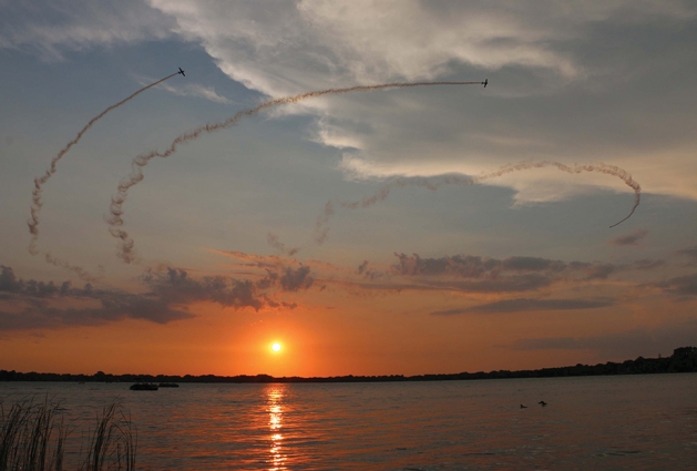 Planes flying over the lake at sunset