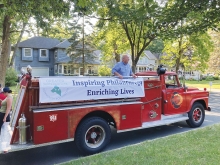 Bill Foussard on a old fashioned fire truck.