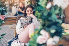 A woman sits reading a book on her newly-remodeled porch