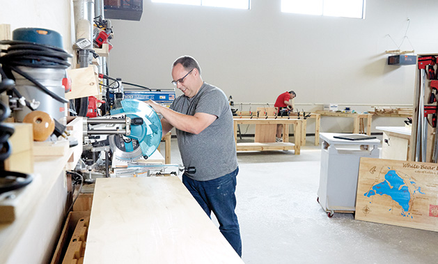 Tom Lendman works on a woodworking project at the White Bear Makerspace